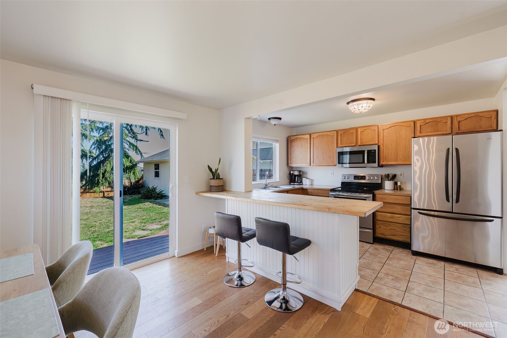 131 Alpine Loop Sequim, WA 98382 - Photo 6 of 19 a kitchen with stainless steel appliances granite countertop a refrigerator a stove a sink a dining table and chairs with wooden floor