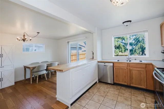 a kitchen with stainless steel appliances kitchen island granite countertop a stove a sink and white cabinets with wooden floor