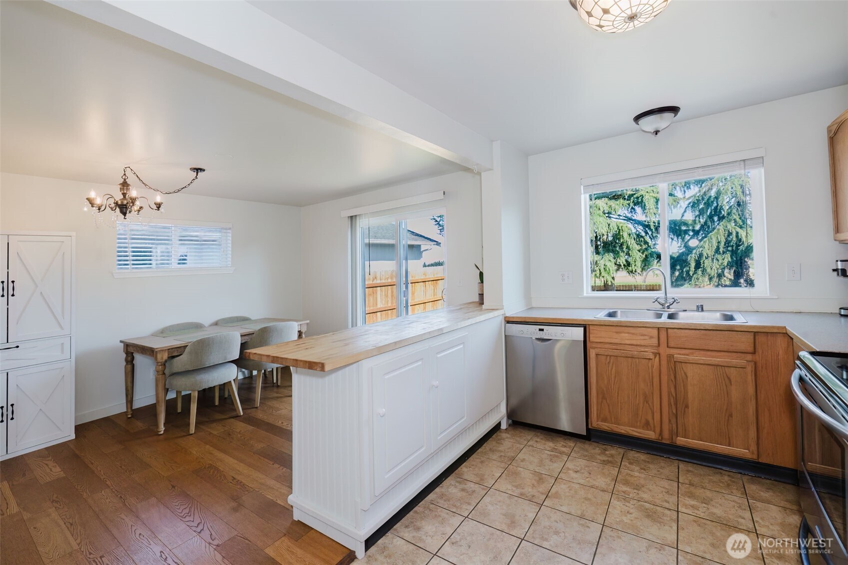 131 Alpine Loop Sequim, WA 98382 - Photo 7 of 19 a kitchen with stainless steel appliances kitchen island granite countertop a stove a sink and white cabinets with wooden floor
