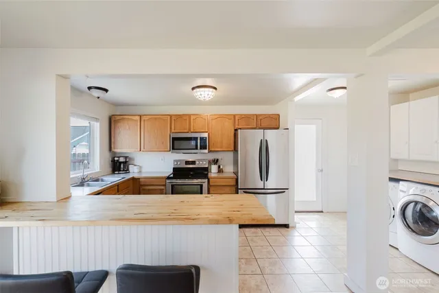 a kitchen with a refrigerator a stove a sink and a stove with wooden floor