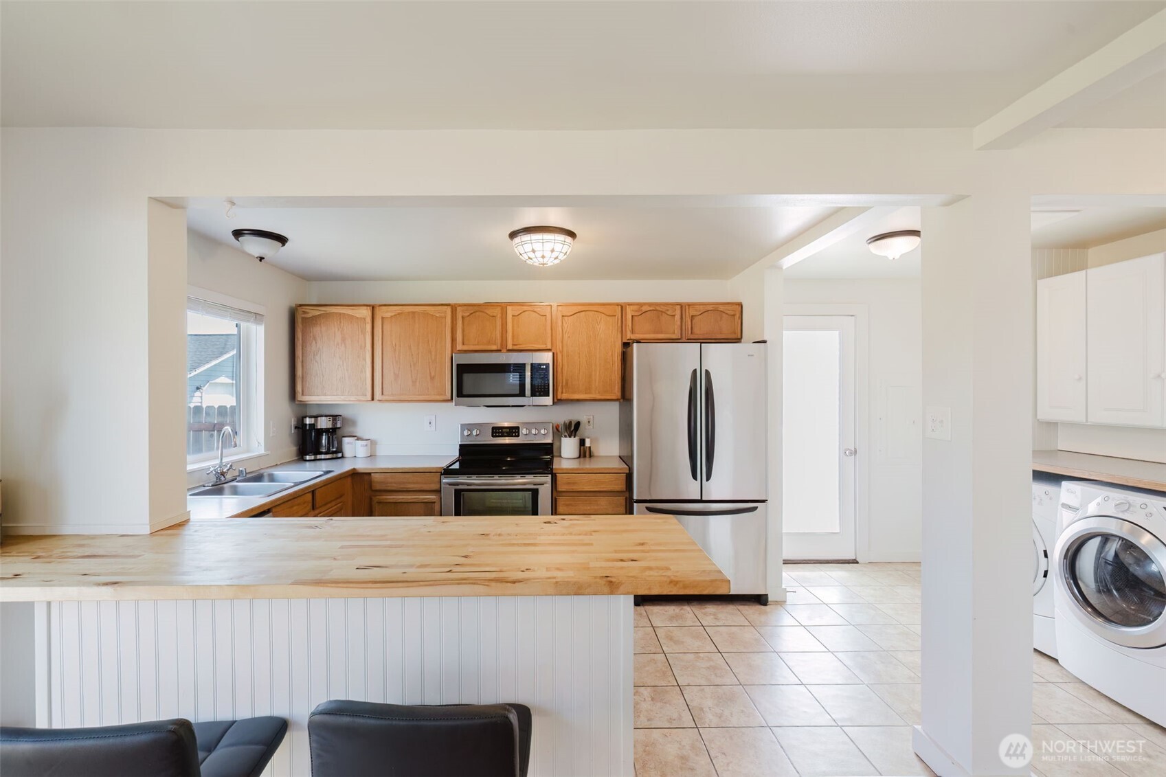 131 Alpine Loop Sequim, WA 98382 - Photo 9 of 19 a kitchen with a refrigerator a stove a sink and a stove with wooden floor