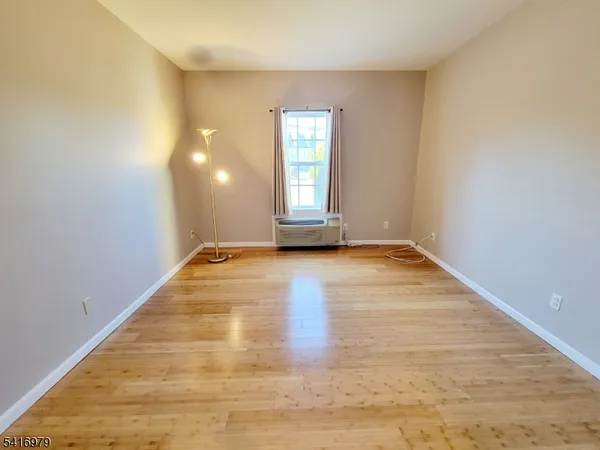 a view of a room with wooden floor and window