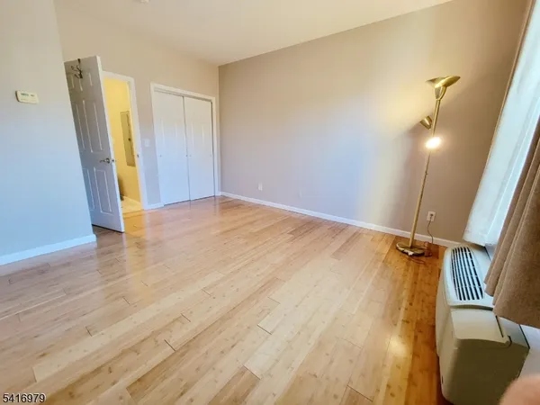 an empty room with wooden floor and cabinet