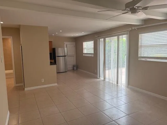 a view of a livingroom with a chandelier fan and windows