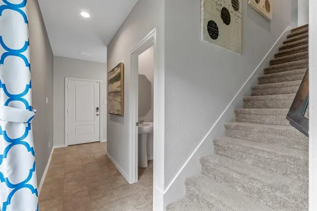 a view of a hallway with wooden floor and a living room