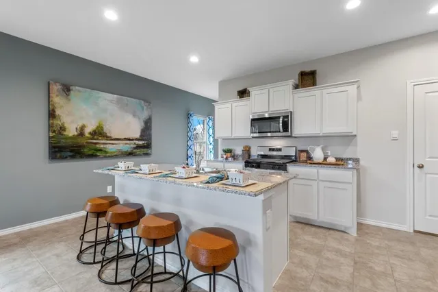 a kitchen with refrigerator and chairs