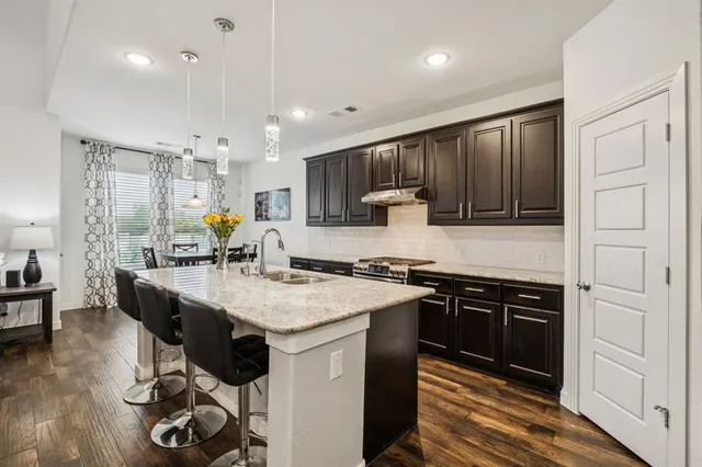 a kitchen with stainless steel appliances granite countertop a sink stove and refrigerator