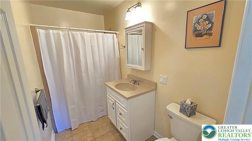 194 Springhouse Road Allentown, PA 18104 - Photo 27 of 34 This bright bathroom features a vanity with a neutral countertop and tiled flooring.