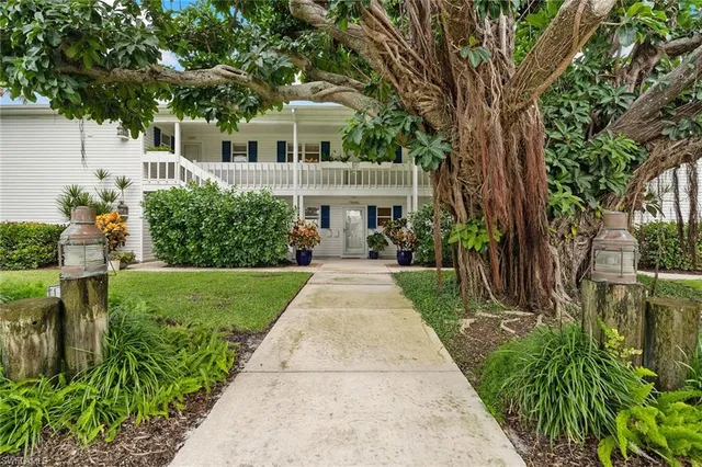a front view of a house with a yard and potted plants