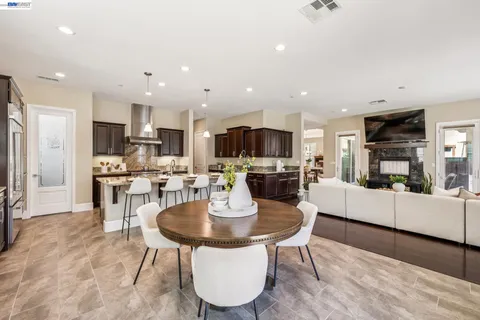 a kitchen with stainless steel appliances kitchen island granite countertop a stove a sink a refrigerator and a refrigerator