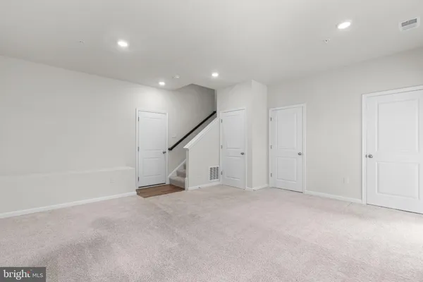 an empty room with stairs and white walls