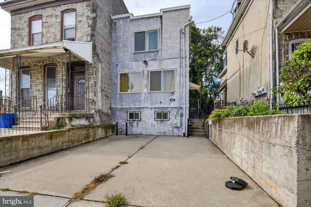 a view of a brick house with many windows and a yard