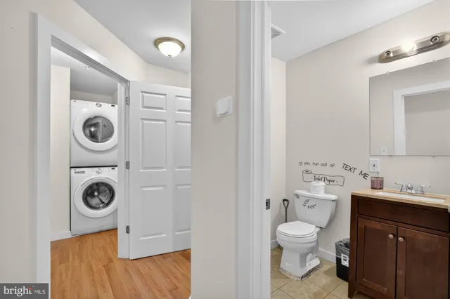 a bathroom with a toilet sink vanity and mirror