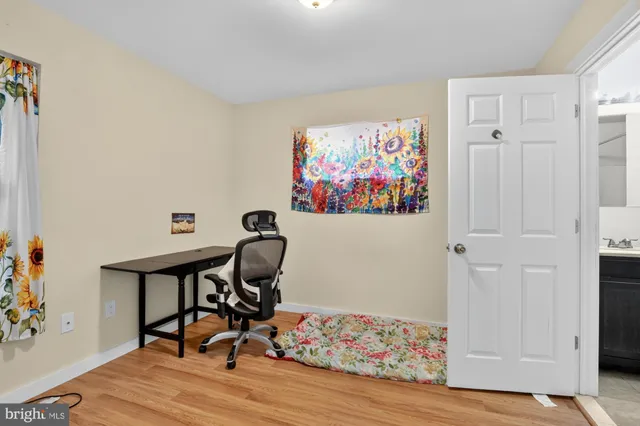 a view of a workspace with furniture and wooden floor