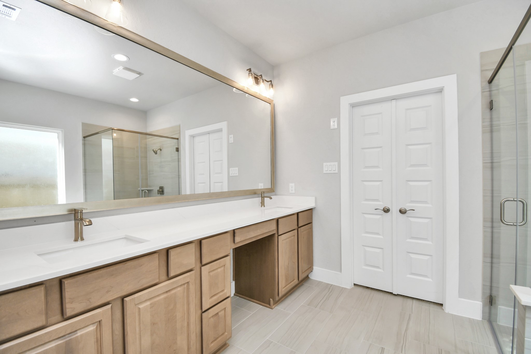 3106 Native Spg Drive Spring, TX 77373 - Photo 24 of 38 Elevate your daily routine at the elegant vanity, now equipped with double sinks, light countertops, modern hardware, and beautiful vanity lights. Sample photo of completed home with similar floor plan. Actual colors and selections may vary.