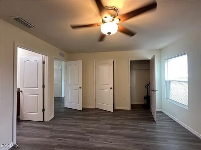 a view of a livingroom with a large window and wooden floor
