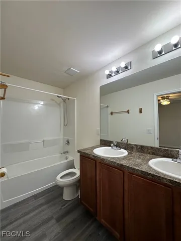 a bathroom with a granite countertop sink a toilet a mirror and shower