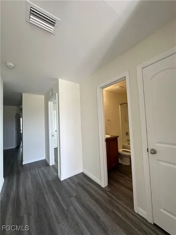 a view of a hallway with wooden floor and closet