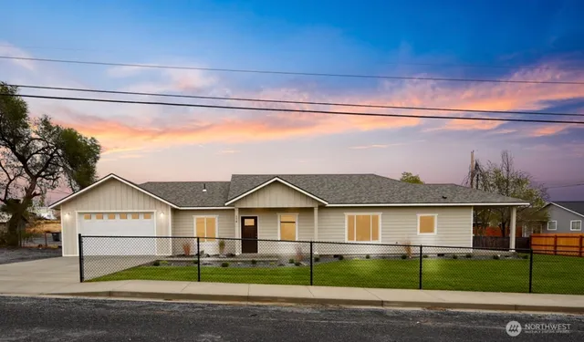 a view of a big house in front of a yard with road