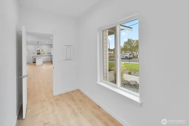a view of empty room with wooden floor and a bathroom