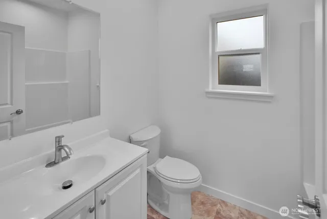 a bathroom with a sink mirror and toilet