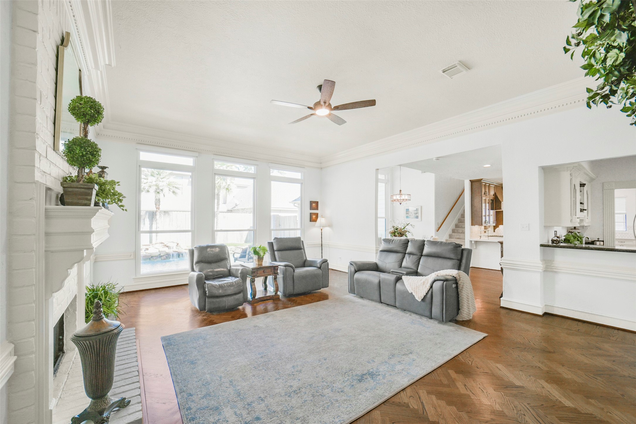 17302 Atherington Place Spring, TX 77379 - Photo 12 of 50 Inviting den opens to the kitchen with rich herringbone flooring, a second fireplace, and seamless indoor-outdoor flow.