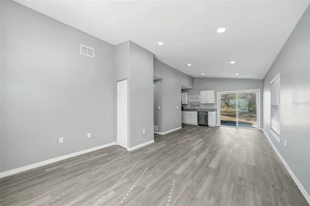 a view of empty room with wooden floor and window