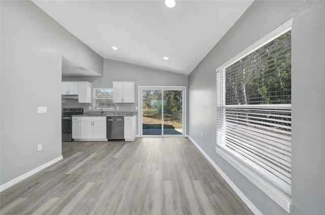 a view of a kitchen with wooden floor and a window