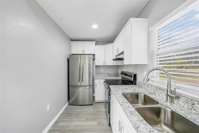 a kitchen with a refrigerator sink and cabinets