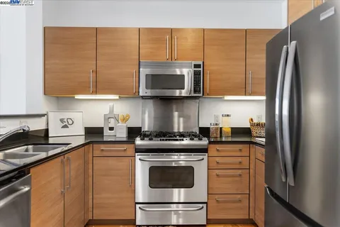 a kitchen with stainless steel appliances granite countertop a stove a sink and a refrigerator