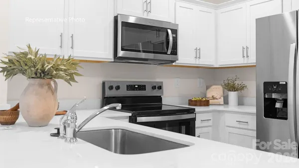 a kitchen with stainless steel appliances granite countertop a sink a stove and a microwave