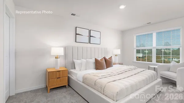 a bedroom with a bed and a large window