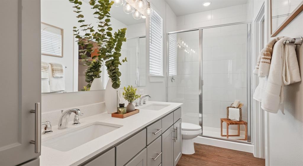 5725 Tanzanite Lane Fort Worth, TX 76123 - Photo 4 of 27 a bathroom with a sink a toilet and a large mirror