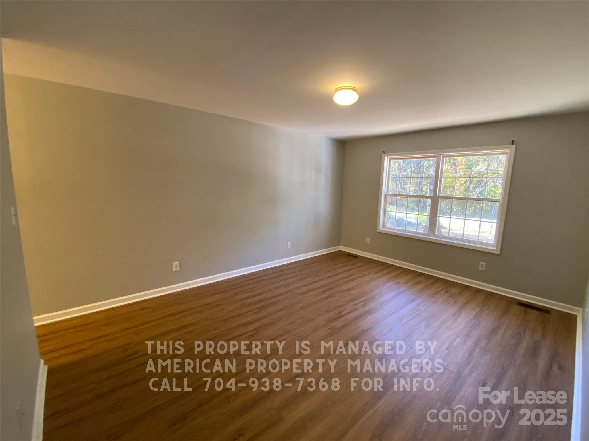 5620 Charlie Walker Road Kannapolis, NC 28081 - Photo 5 of 12 an empty room with wooden floor and windows