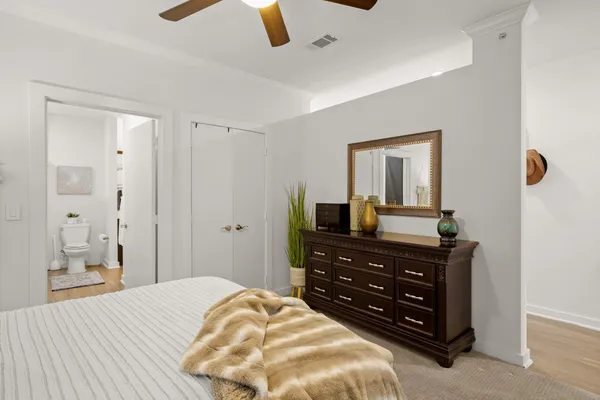 a bedroom with a bed and a mirror on the dresser