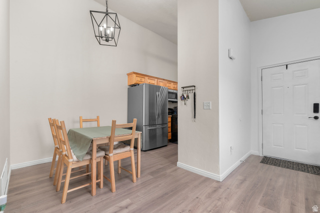 25 West Ridge Road, Unit 25 Saratoga Springs, UT 84045 - Photo 4 of 22 Open-concept living area with wood-finish flooring, a modern geometric chandelier, and vaulted ceilings
