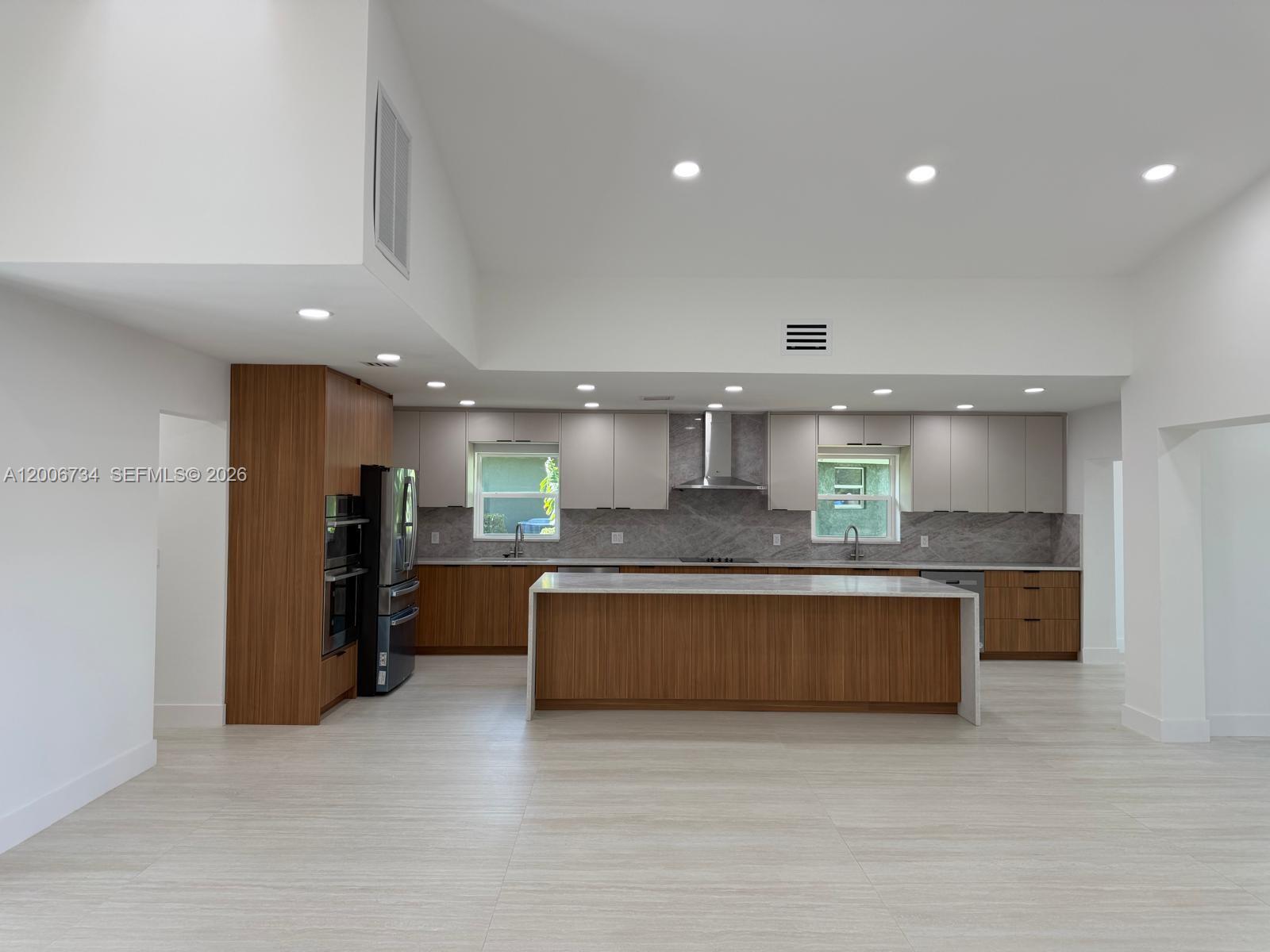 a large kitchen with stainless steel appliances granite countertop a large counter top and a couch