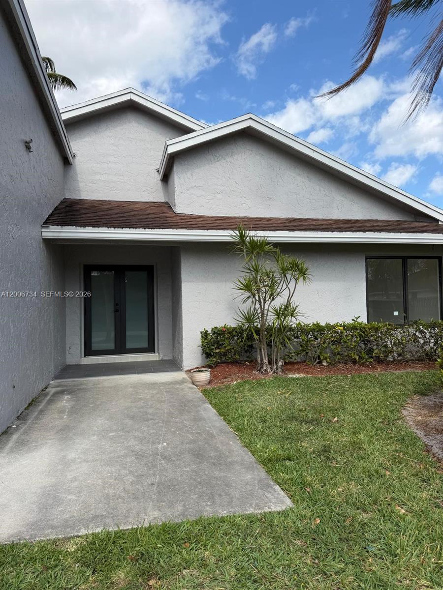 7917 Chula Vista Crescent Boca Raton, FL 33433 - Photo 7 of 28 a front view of a house with garden