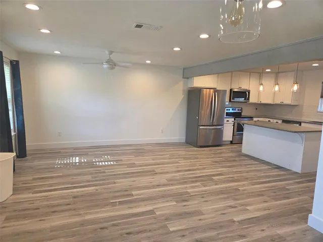 a view of a kitchen with a refrigerator and a stove