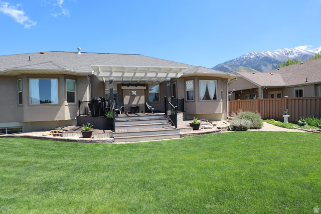 1055 North 1000 East Mapleton, UT 84664 - Photo 91 of 112 Expansive backyard featuring a manicured lawn, multi-level wood-finish deck with integrated steps, and a pergola-covered patio area
