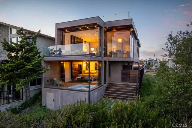 a view of a house with large windows and a small yard