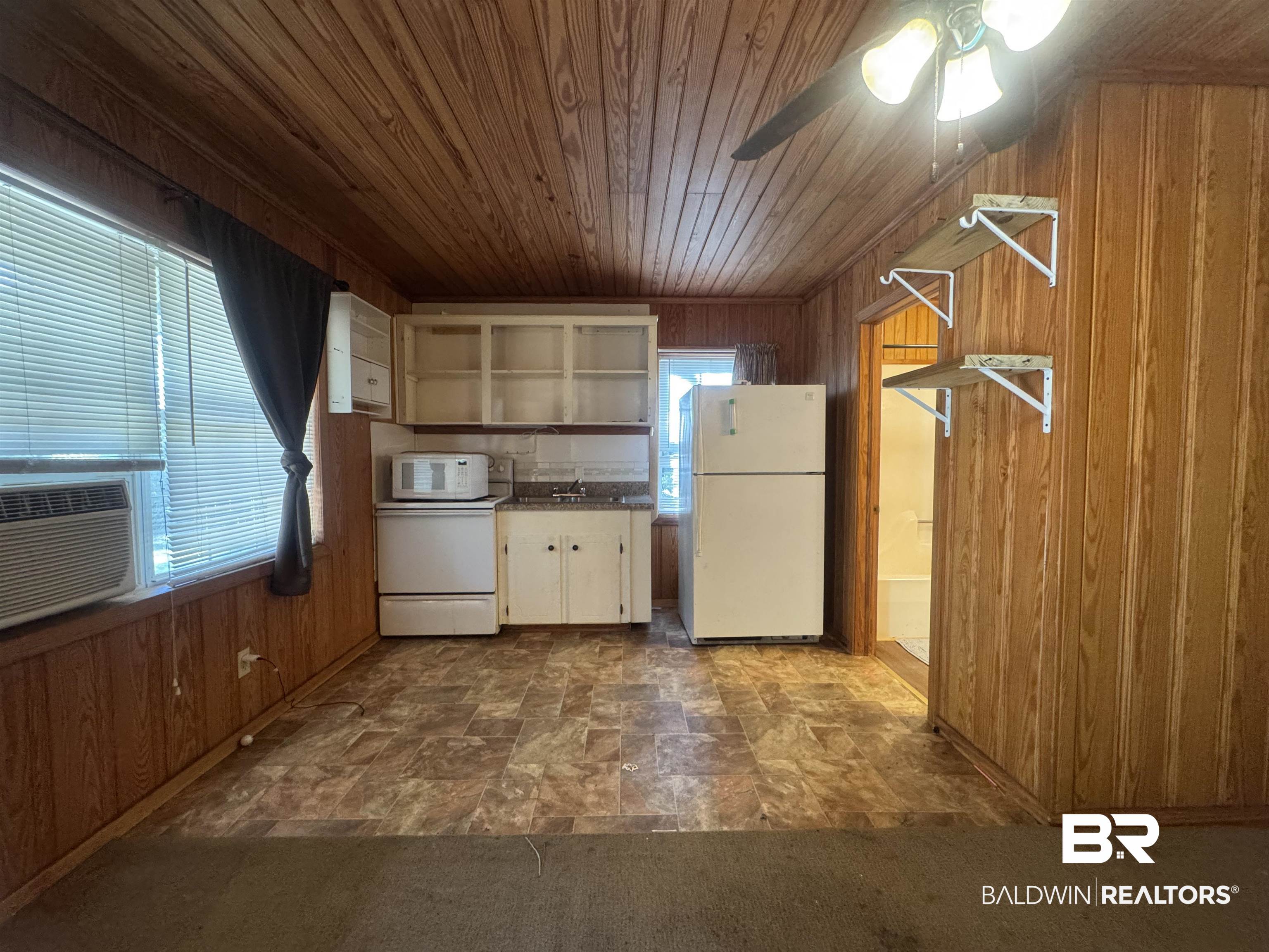 3097 Old Castleberry Road Brewton, AL 36426 - Photo 42 of 49 Kitchen with ceiling fan, wooden ceiling, sink, wooden walls, and white appliances