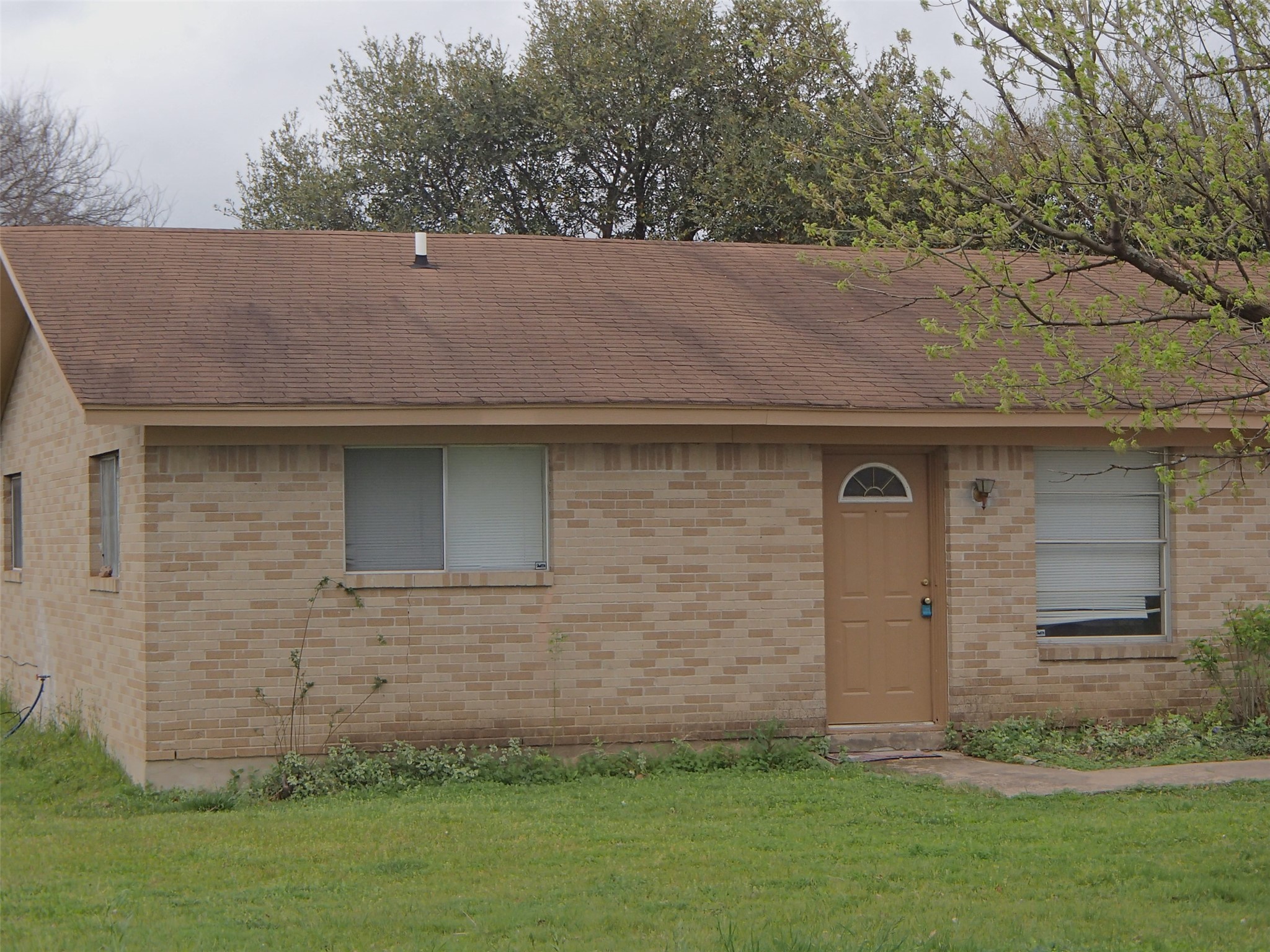 2500 Parker Drive, Unit A Georgetown, TX 78628 - Photo 2 of 9 Ranch-style home with a front yard, roof with shingles, and brick siding
