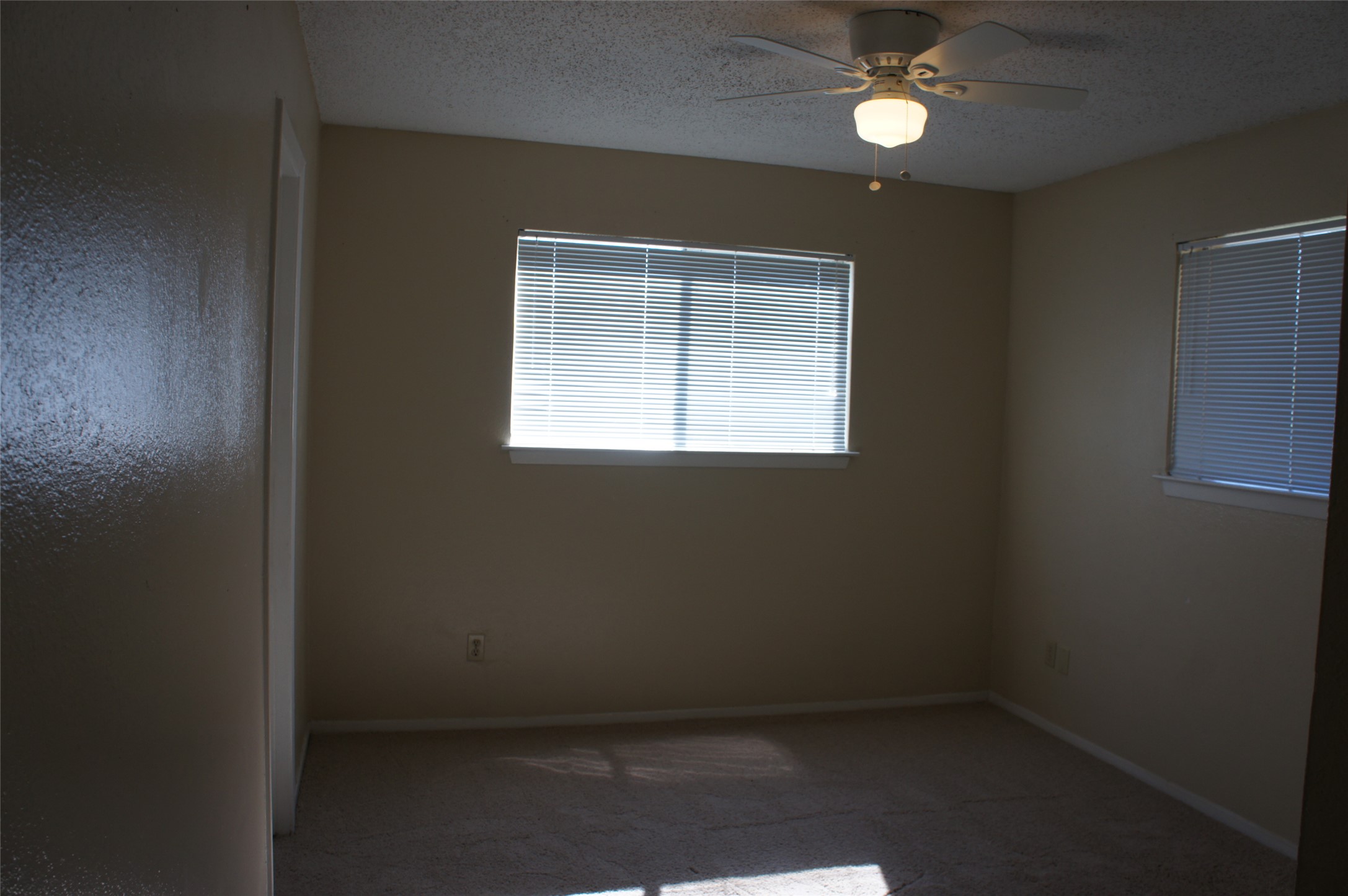 2500 Parker Drive, Unit A Georgetown, TX 78628 - Photo 7 of 9 Carpeted spare room featuring a textured ceiling and a ceiling fan