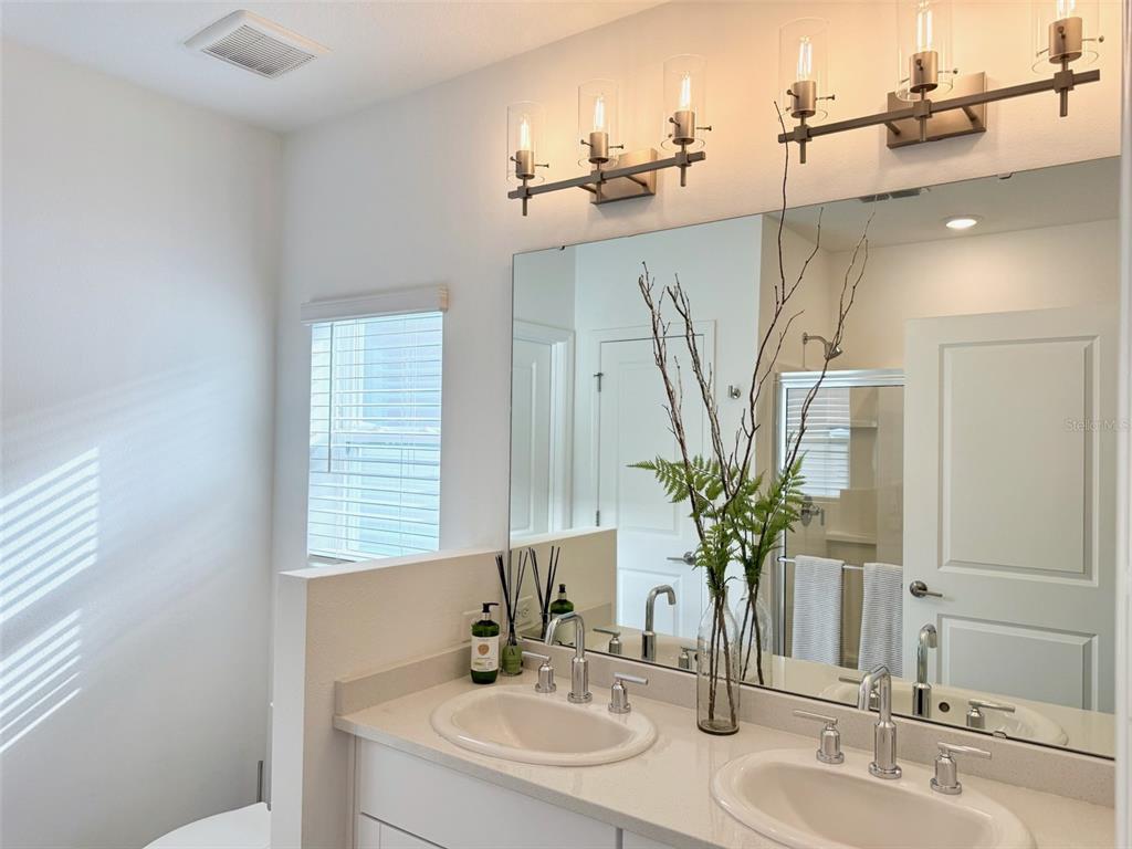 1126 Calico Pointe Circle Groveland, FL 34736 - Photo 16 of 28 a bathroom with a sink a mirror and a potted plant