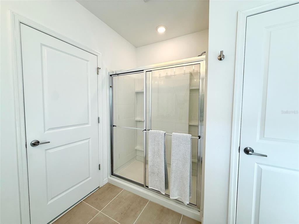 1126 Calico Pointe Circle Groveland, FL 34736 - Photo 17 of 28 a bathroom with a glass shower door