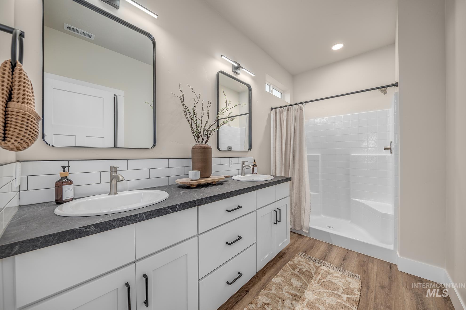 1367 Hansen Road Weiser, ID 83672 - Photo 14 of 36 Full bath with double vanity, a shower stall, and light wood-style flooring