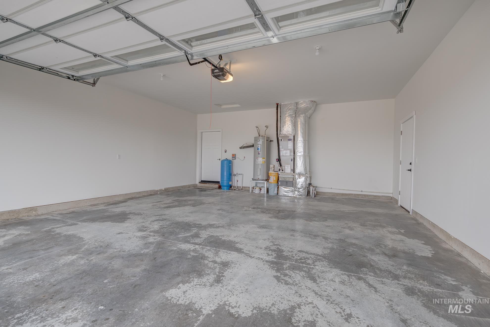 1367 Hansen Road Weiser, ID 83672 - Photo 24 of 36 Garage with heating unit, electric water heater, and a garage door opener