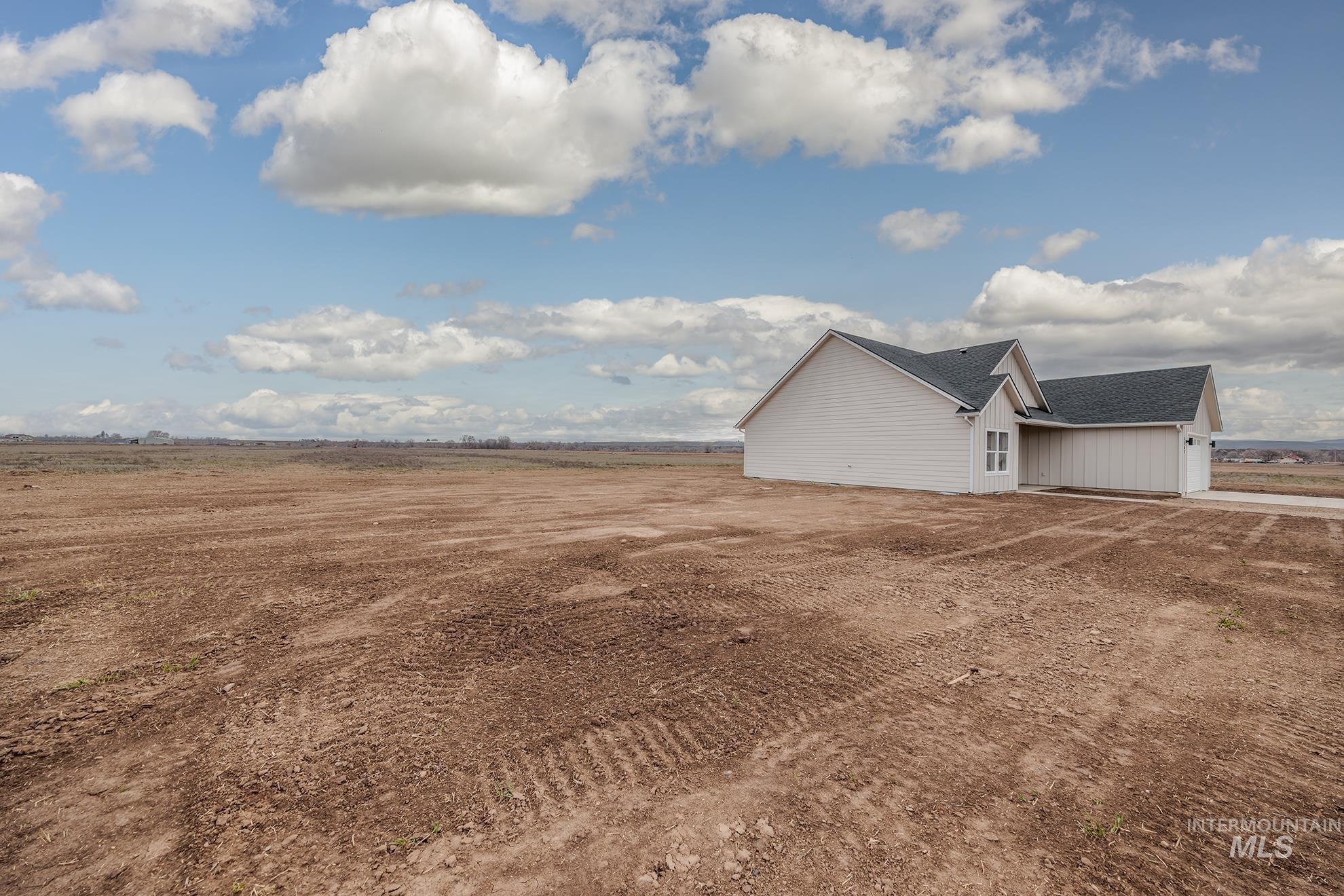 1367 Hansen Road Weiser, ID 83672 - Photo 27 of 36 View of side of property featuring a garage, roof with shingles, a view of rural / pastoral area, and driveway