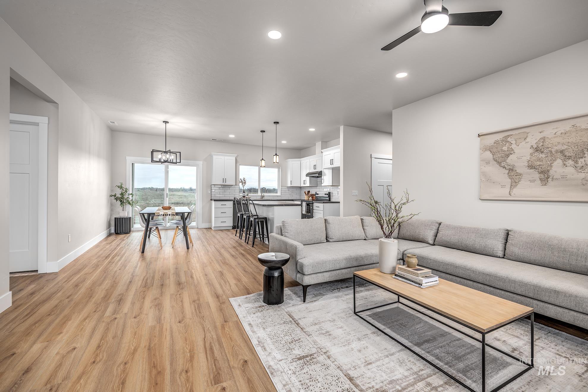 1367 Hansen Road Weiser, ID 83672 - Photo 5 of 36 Living room with light wood-type flooring, ceiling fan, and hanging lights